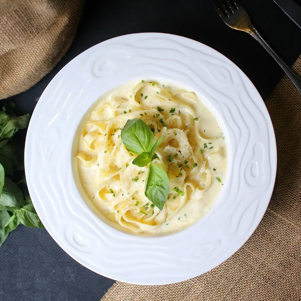 Alfredo Sauce Recipe: Creamy sauce drizzled, with a sprinkle of Parmesan cheese and fresh herbs.