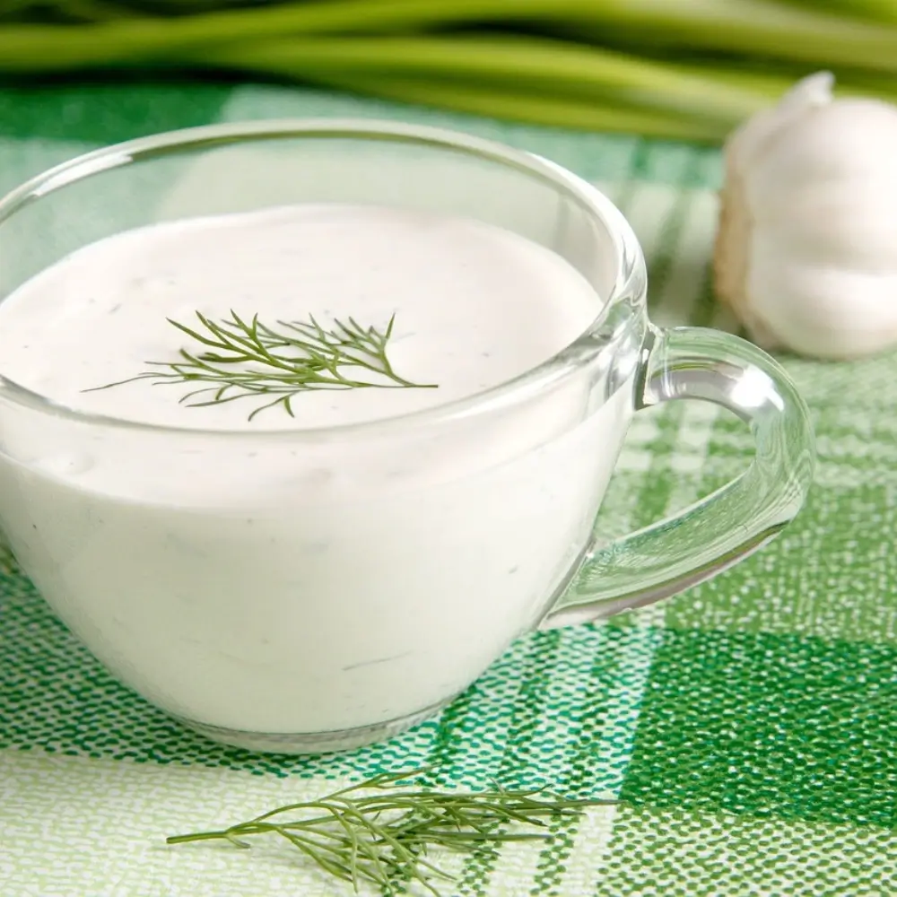 Creamy Alfredo sauce drizzled over pasta, with a sprinkle of Parmesan cheese and fresh herbs.