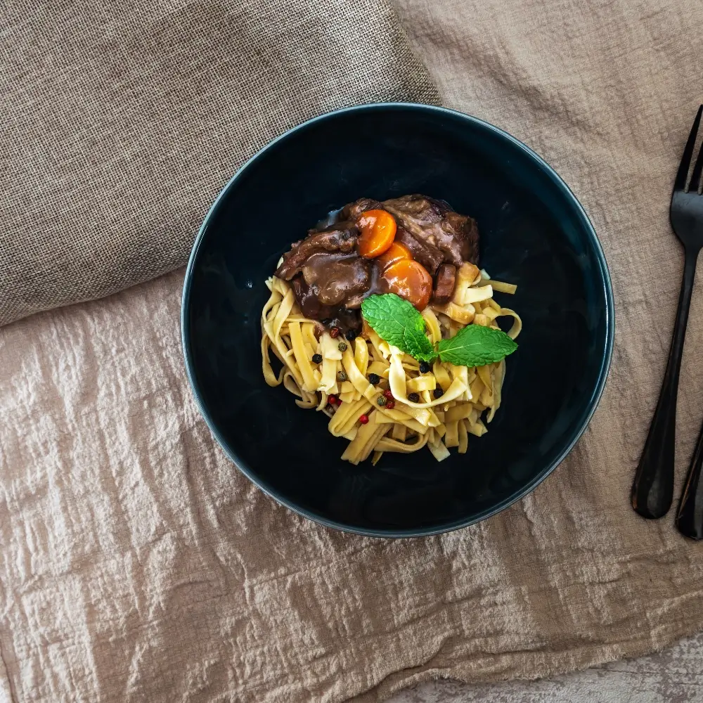 A hearty bowl of beef bourguignon, rich with tender beef, vegetables, and a flavorful sauce.