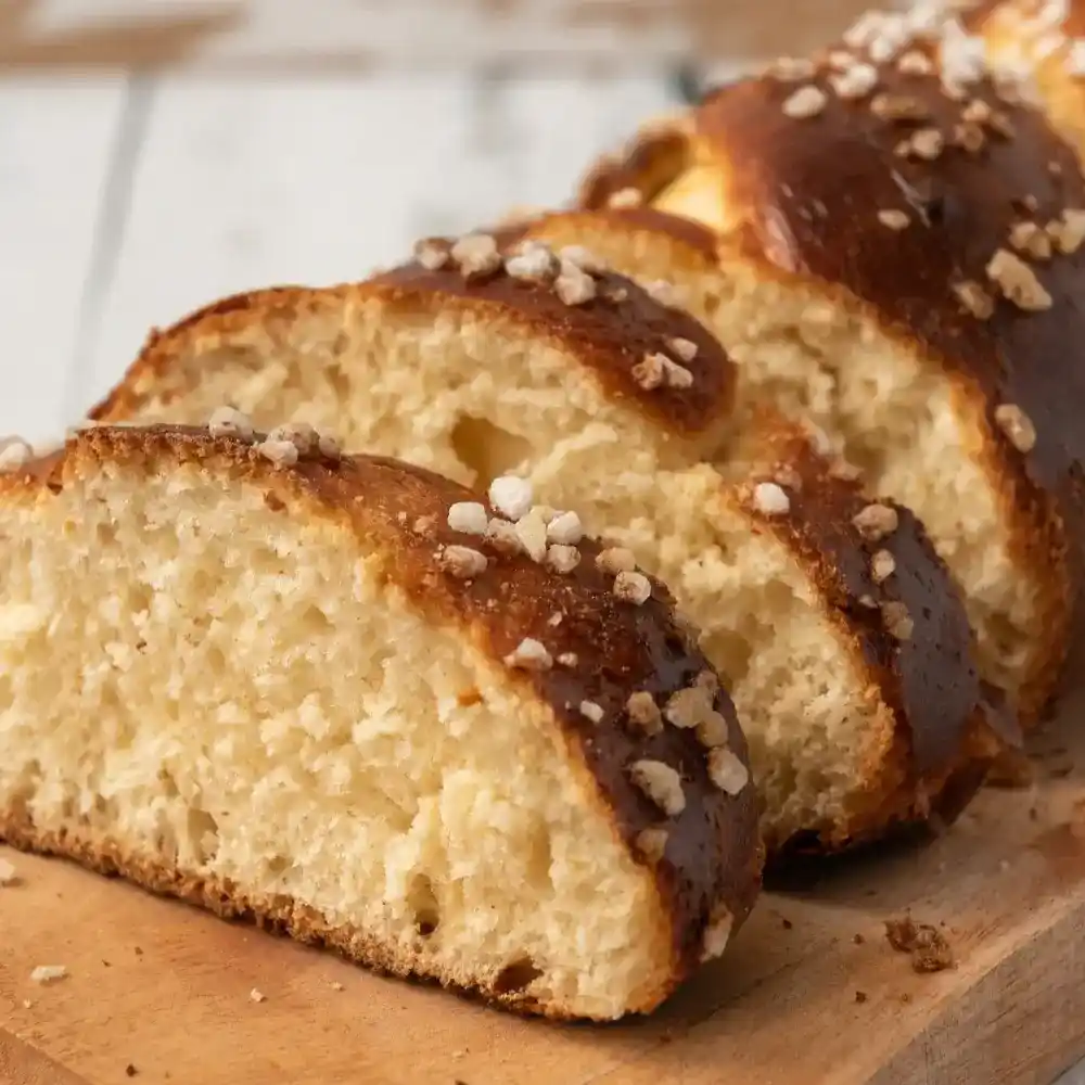 Soft, golden-brown brioche loaf with a light and airy texture, sliced to show its buttery crumb.