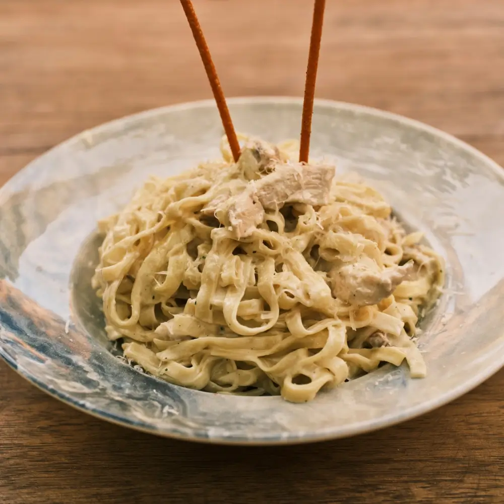 A creamy Cajun fettuccine Alfredo sauce, rich and spicy, coating perfectly cooked fettuccine pasta.