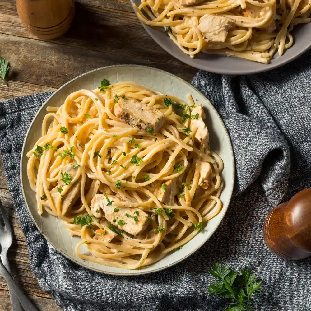 A creamy Cajun fettuccine Alfredo sauce, rich and spicy, coating perfectly cooked fettuccine pasta.