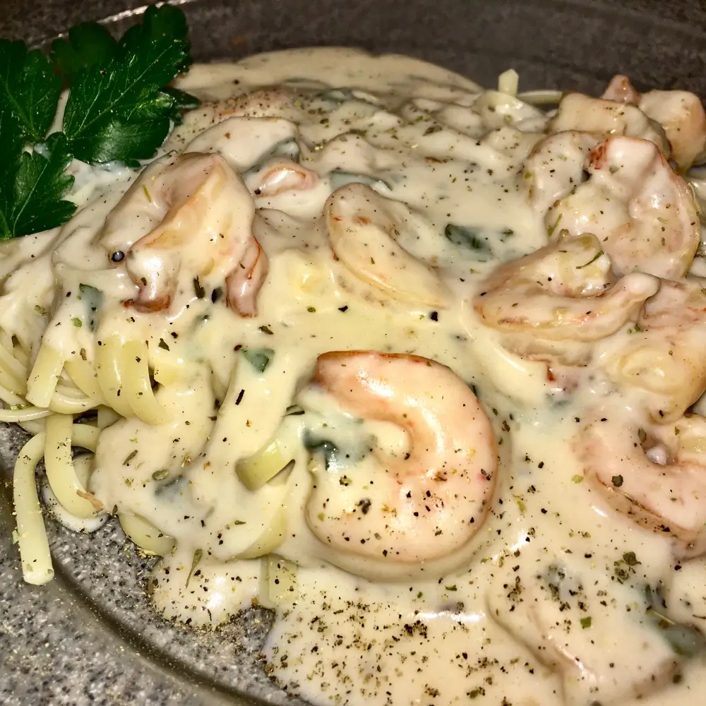 A creamy Cajun fettuccine Alfredo sauce, rich and spicy, coating perfectly cooked fettuccine pasta.