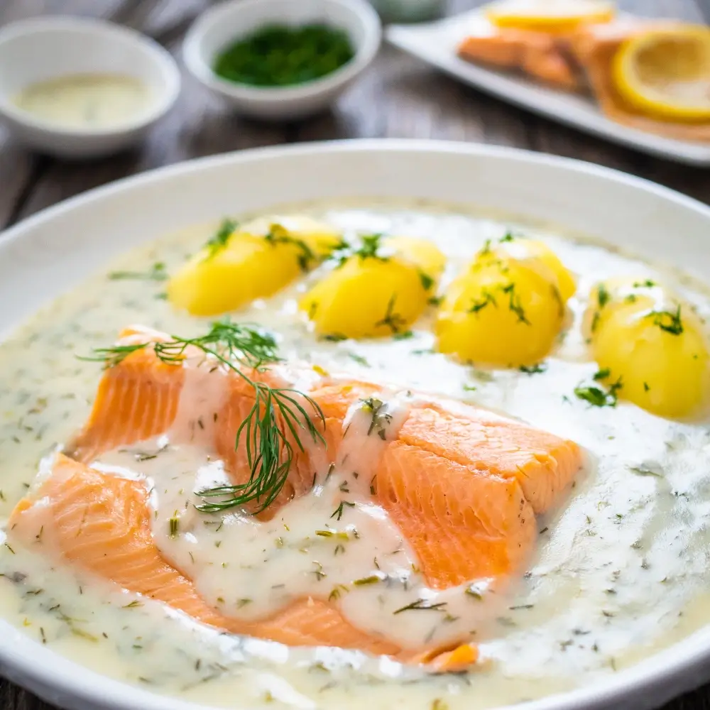 Creamy Salmon Recipe: A serving of creamy salmon, topped with a rich and velvety sauce, garnished with fresh herbs and served with vegetables.