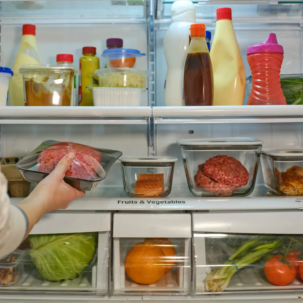 A person using proper food safety techniques, such as washing hands and sanitizing kitchen tools, while preparing fresh ingredients.