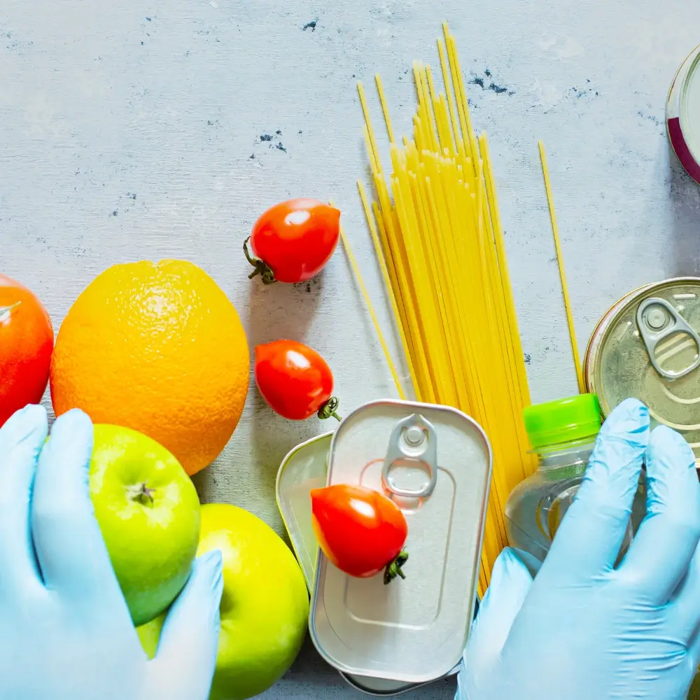 A person using proper food safety techniques, such as washing hands and sanitizing kitchen tools, while preparing fresh ingredients.