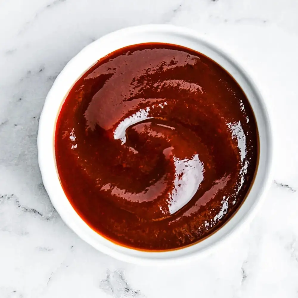 A rich and smoky homemade barbecue sauce in a jar, perfect for grilling, dipping, or marinating meats and vegetables.