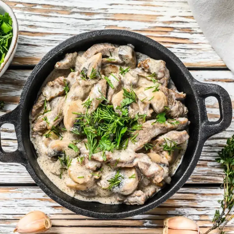 A plate of creamy beef stroganoff, with tender beef slices in a rich, creamy mushroom sauce, served over egg noodles.