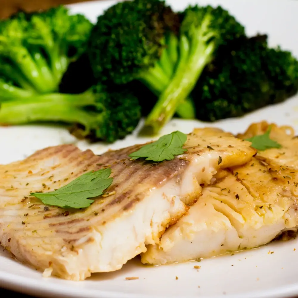 A perfectly cooked tilapia fillet, golden and crispy on the outside, tender and flaky on the inside.