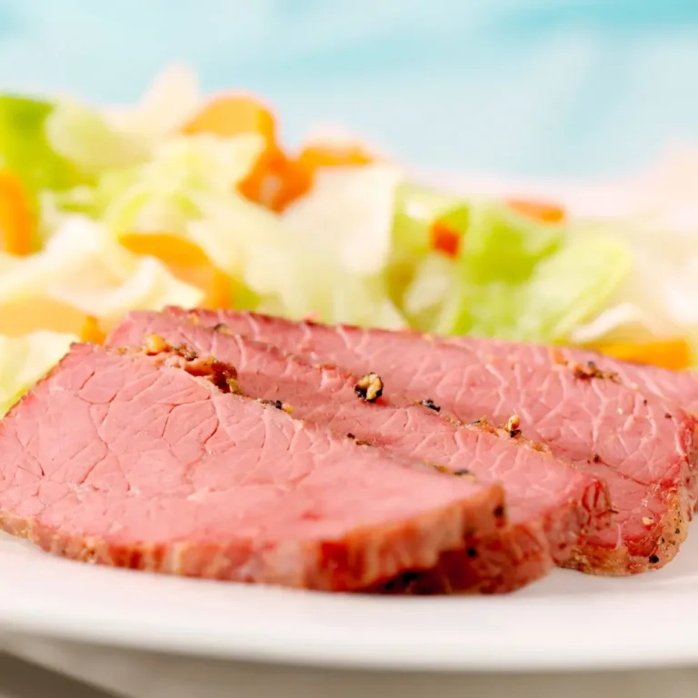 A plate of corned beef and cabbage, with tender corned beef slices and steamed cabbage, served with mustard or sauce.