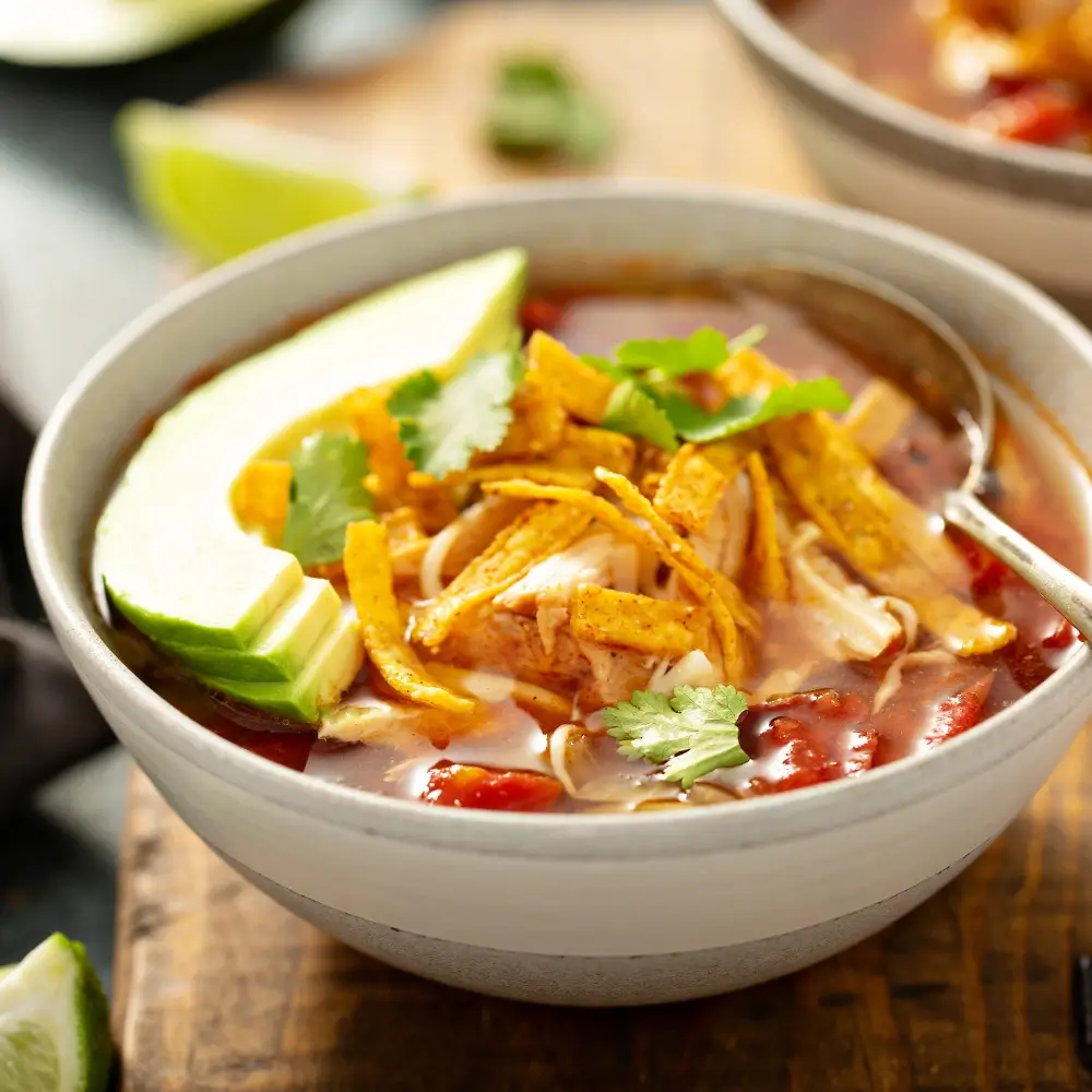 A taco soup recipe, loaded with hearty vegetables, beans and a flavorful broth, topped with crispy fried tortilla strips.